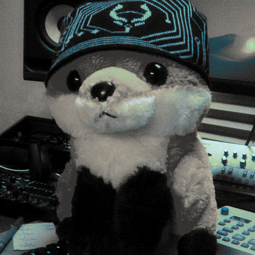 Photograph of Chubbles the fox surrounded by various music gear.